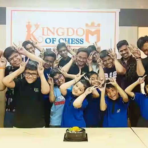 Coaches and students of Kingdom of Chess celebrating together under the academy wordmark